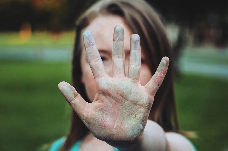 eine Frau die mit ihrer Hand eine Stopp Geste zeigt